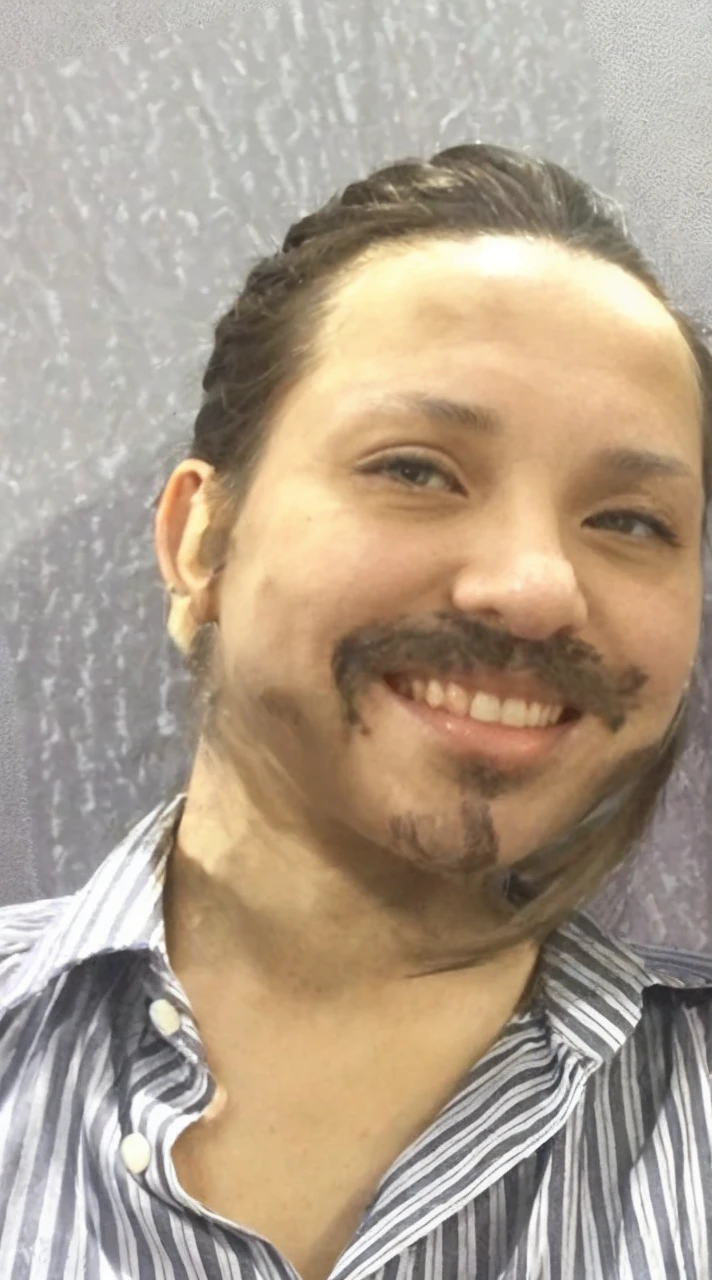 Put a ponytail in this person's hair in the photo.