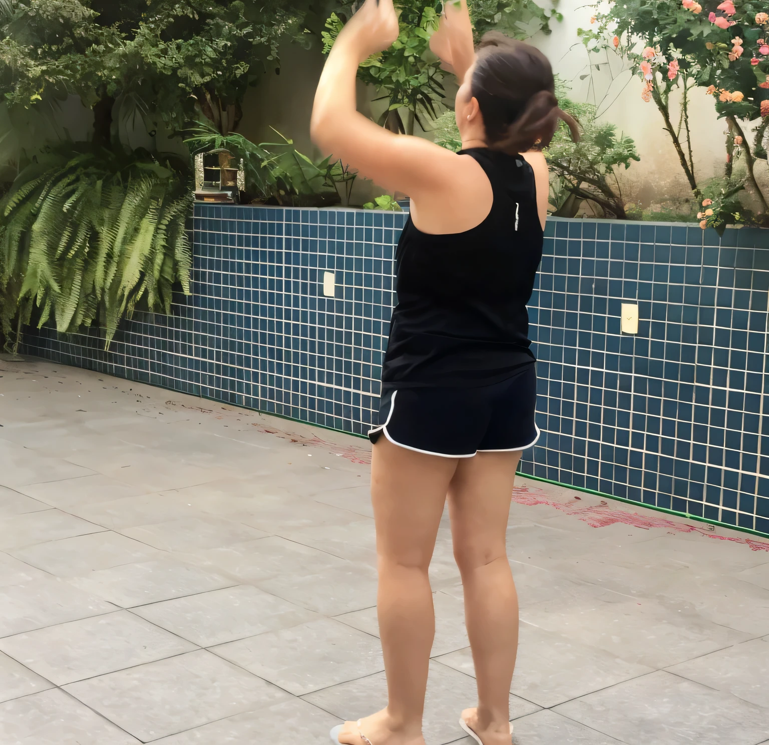 woman in black shirt and shorts playing with a frisbee on a tiled patio, squatting down next to a pool, side view of her taking steps, back - shot, back and standing, backshot, back pose, in full growth from the back, outside, long shot from back, twirling, back - view, full growth from the back, back shot