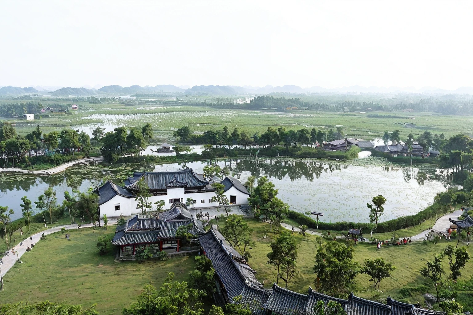 This is an oil painting,Large freehand oil painting,International Oil Painting Master,International Art Exhibition Award-winning Works,There are Hui-style buildings,There is a big house,There is a pond in the middle, a small village with a lake, Top view angle, Chinese Village, Bird's eye view, old Chinese building, Viewed from slightly above, Green lawn,