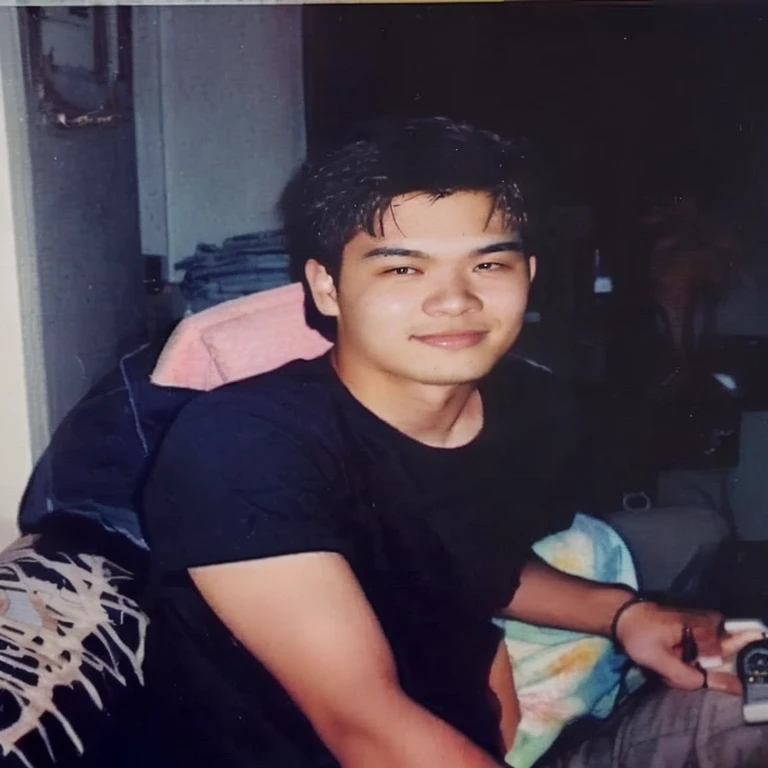 There was a man sitting on the bed with a remote control., Approximately 19 years old, 2 s, 2 8 year 2 9 yearmian Taken in the mid-2000s, 3 2 years old, 2 3 years rs old, 25 years about 30 years old.
