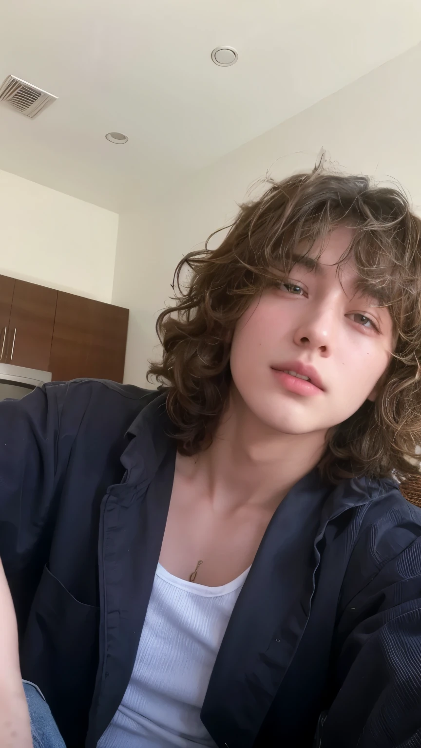 arafed man sitting on a sofa with a skateboard in his hand, he has short curly brown hair, su cabello esta desordenado y descuidado, su cabello es desordenado y salvaje, timothy chalamet, pelo rizado desordenado, yuya nagai, xqc, Finn Wolfhard, pelo superior rizado y corto, peinado grande y desordenado, long pelo rizado desordenado
