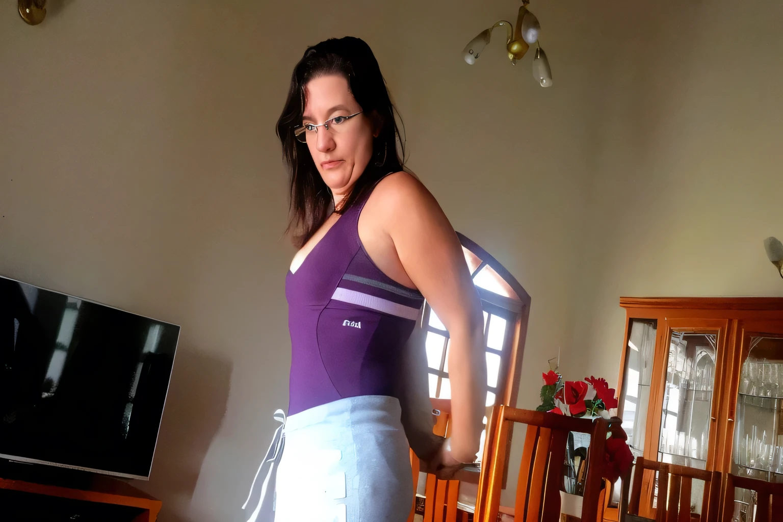 there is a woman standing in a living room with a remote, wearing purple undershirt, violet tight tanktop, middle shot waist up, waist - shot, wearing tanktop, view from the back, wearing leotard, wearing a camisole and shorts, wearing a low cut tanktop, wearing a tanktop, profile shot, very tight corset