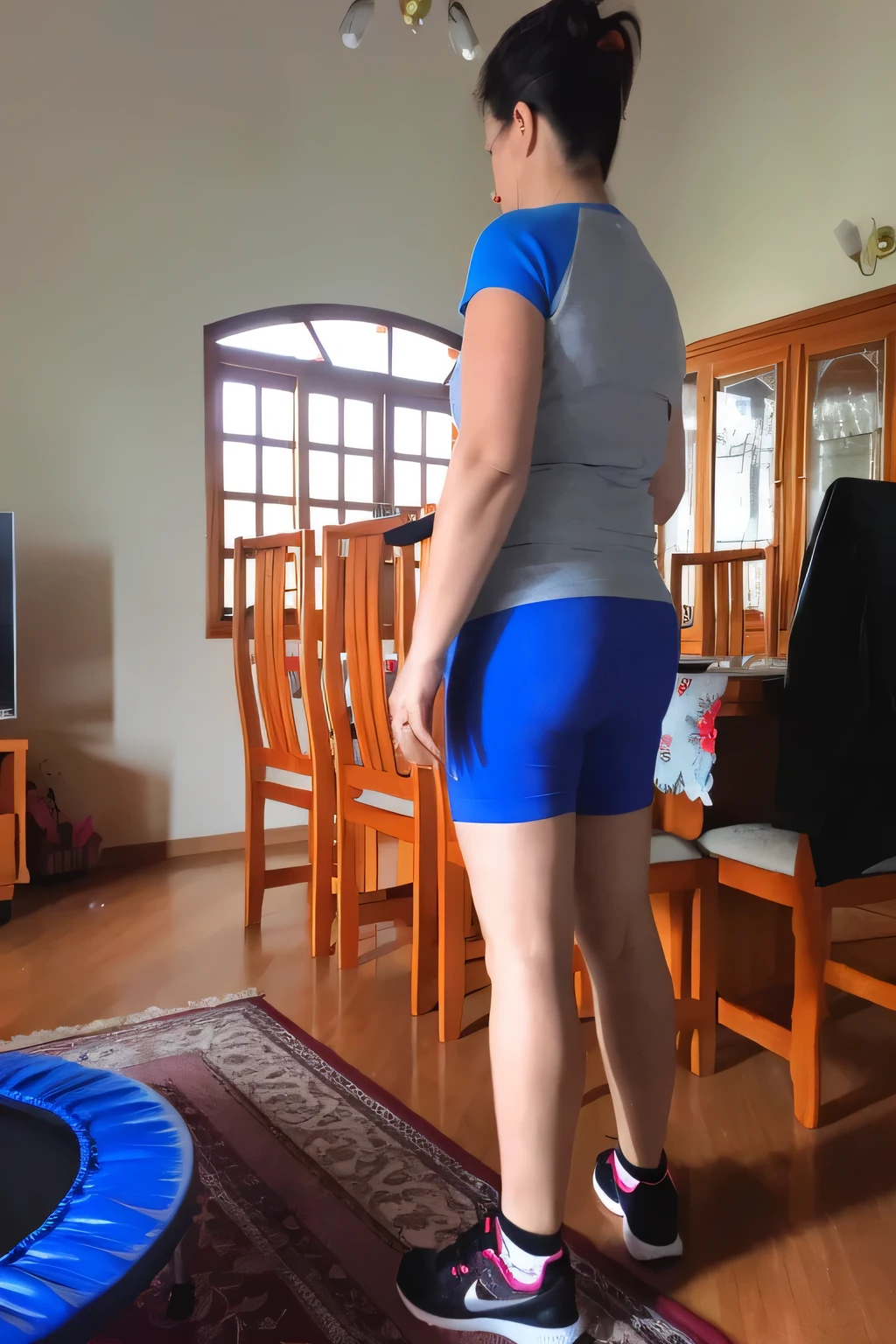 there is a woman standing in a living room with a trampol, side view of her taking steps, back and standing, view from the back, middle shot waist up, in shorts, long shot from the back, shot from the back, leg and hip shot, shapely toned derriere, toned derriere, waist reaching ponytail