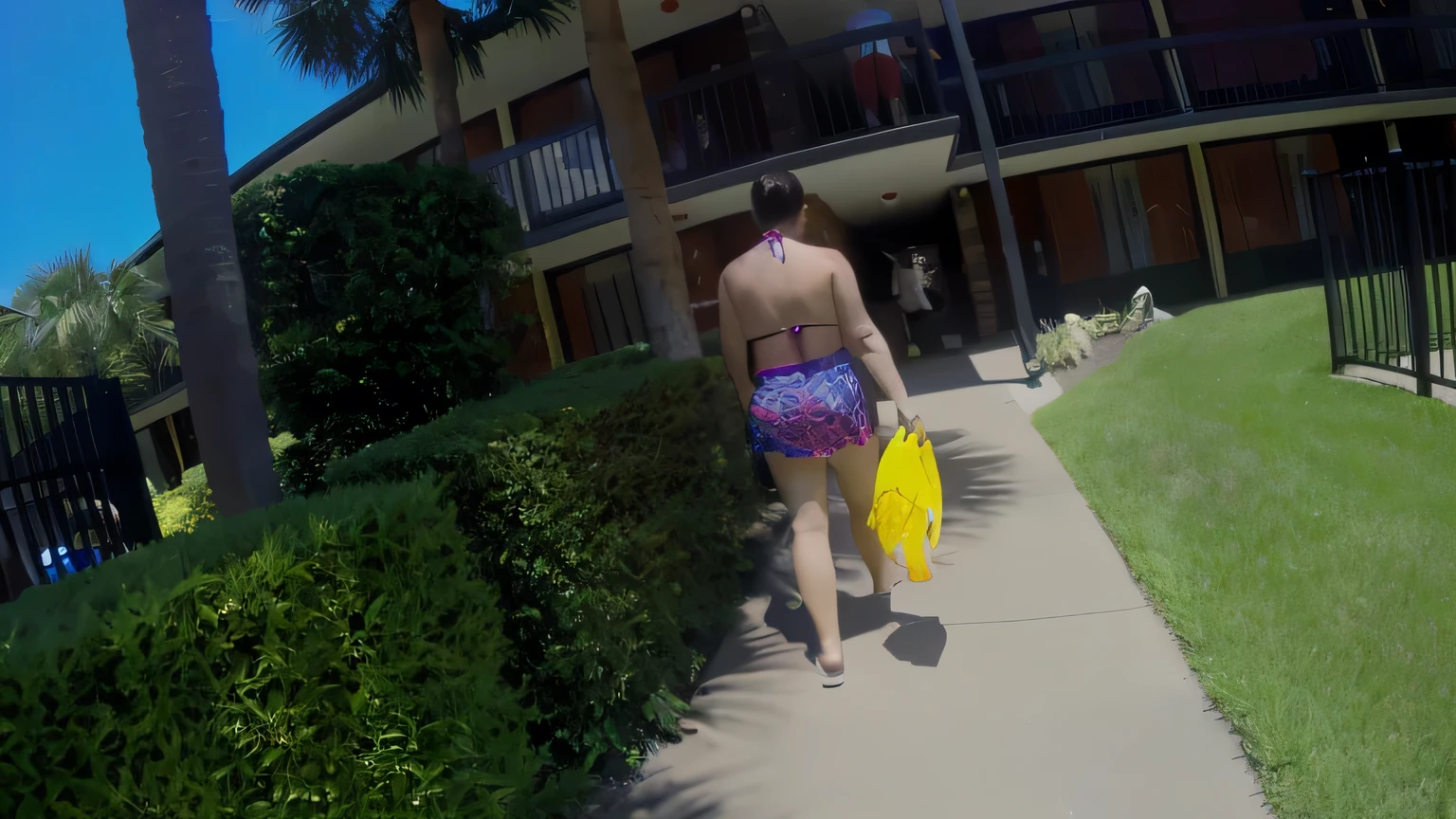 there is a woman walking down the sidewalk with a yellow frisbee, walking away from the camera, walking away from camera, shot on gopro9, taken on go pro hero8, walking towards camera, go pro footage, gopro footage, vacation photo, pov photo, next to a pool, walking towards the camera, in a yellow bikini, is wearing a swimsuit