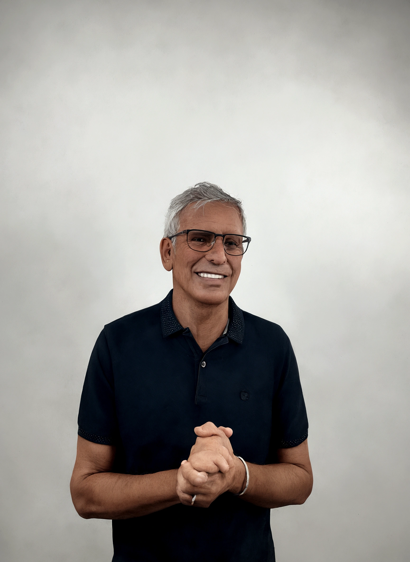 Slim man, smiling wearing glasses, in a square