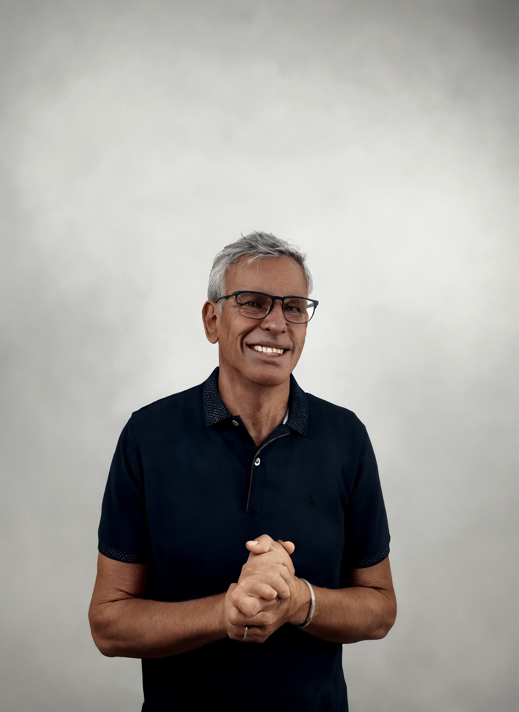 Slim man, smiling wearing glasses, in a square