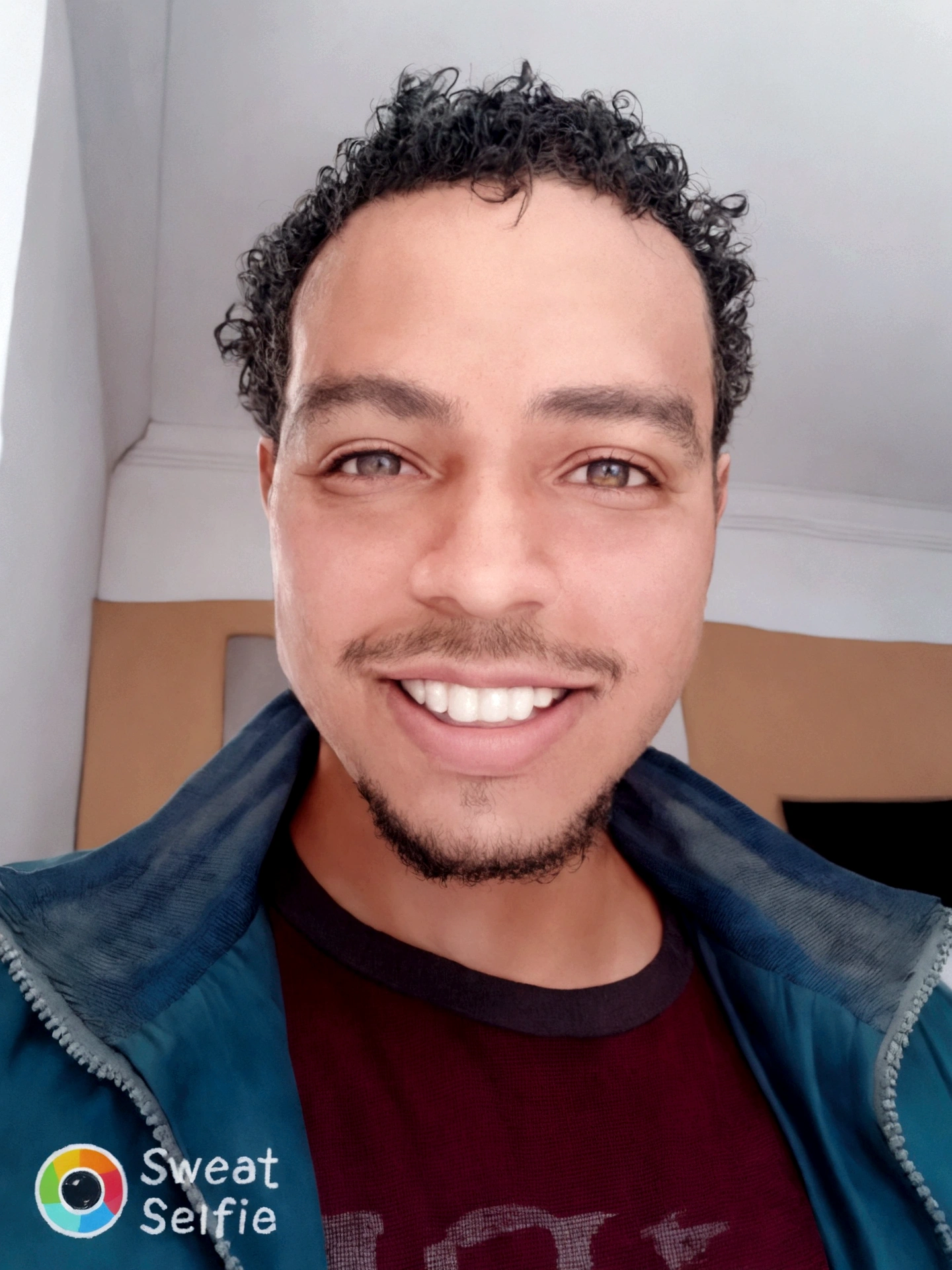 homem sorridente com cabelos cacheados e uma jaqueta, Mohammed Chahin, caio santos, icaro carvalho, atef., david rios ferreira, Riyad Cassiem, Mohamed Reda, East African man with curly hair, edu souza, ismail, sorrindo e olhando diretamente, Saâdane afif, outras shulzes, carmelo blandino, sem barba