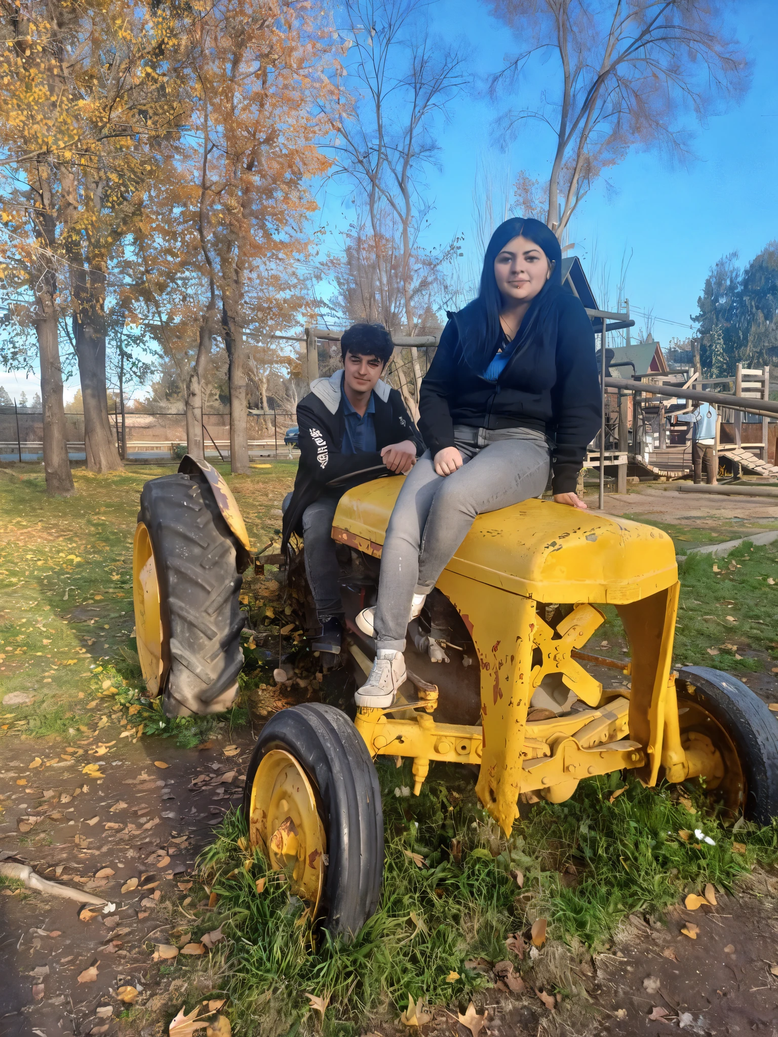 Hay un hombre y una mujer vestidos con poleras azules y polerones abiertos negros arriba de un tractor amarillo