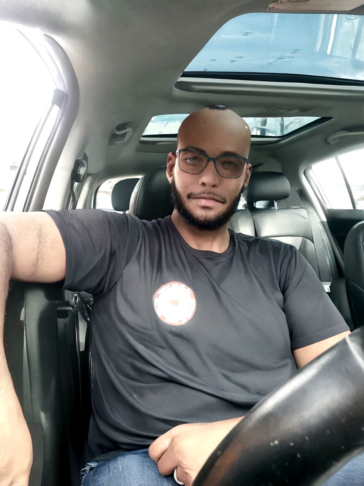 bald, with beard, smiling, black shirt and wears glasses