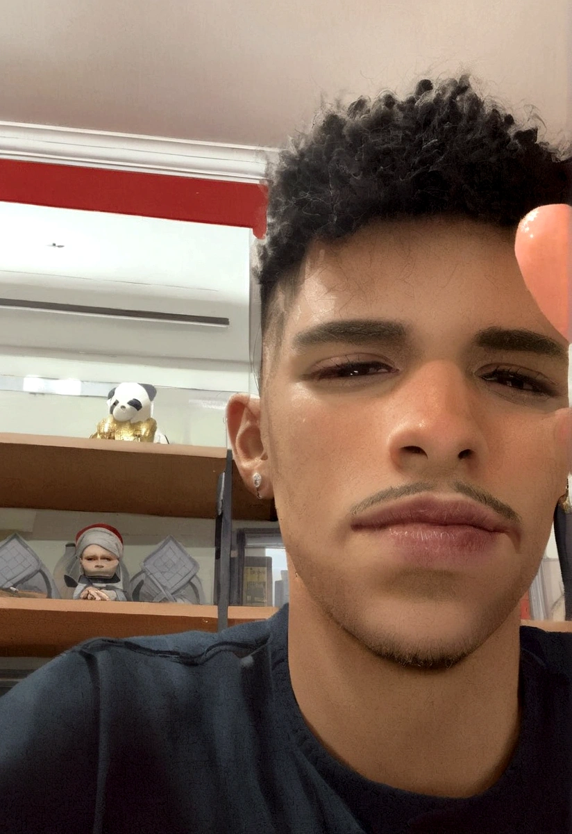 Homem com leve sorriso no rosto, brinco na orelha