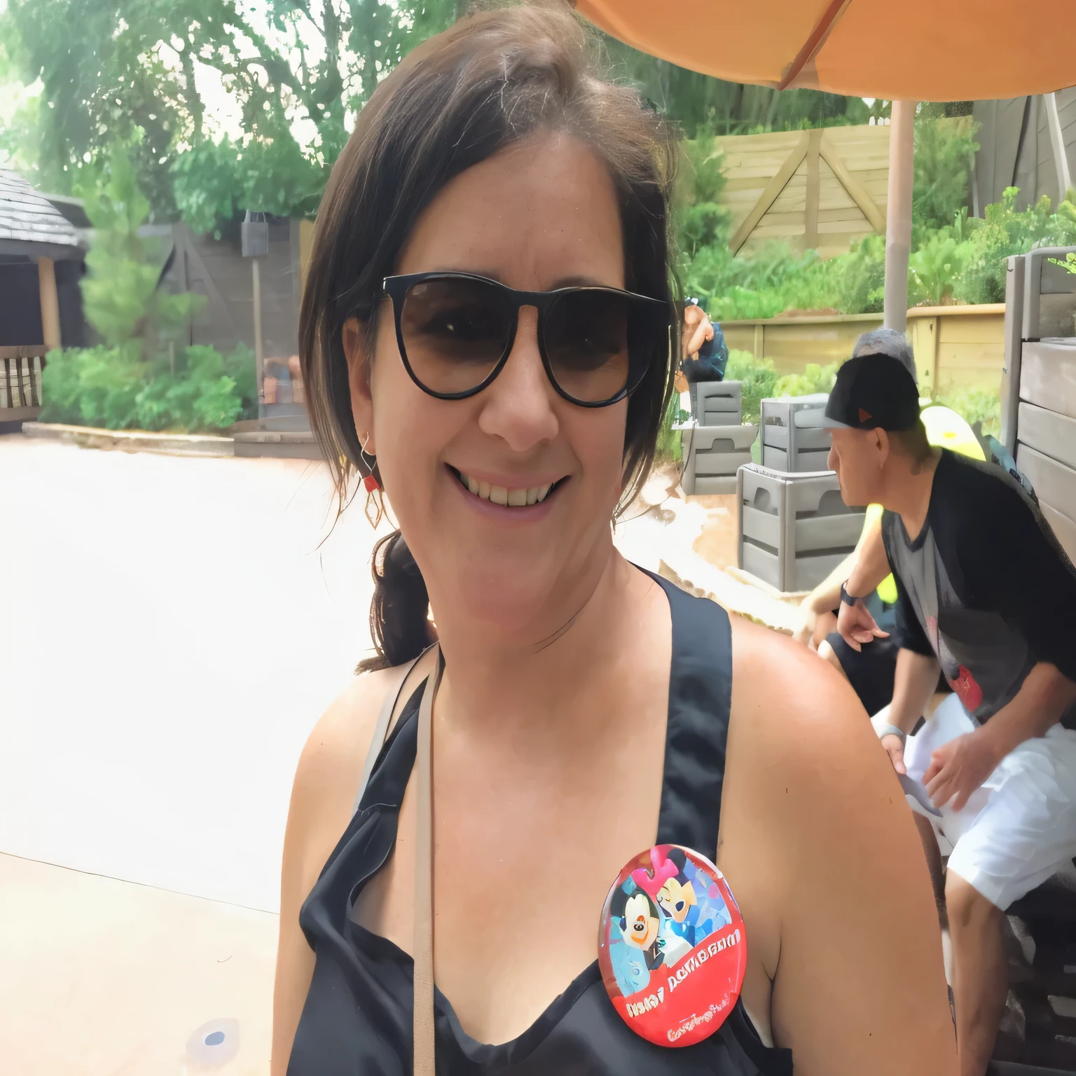 smiling woman in sunglasses with a pin on her chest, disney artist, having a great time, sandra, slightly smiling, very slightly smiling, profile image, roxie vizcarra, having a good time, profile pic, photo taken in 2018, very silly looking, jenna barton, looking off to the side, not blurry, julie heffernan