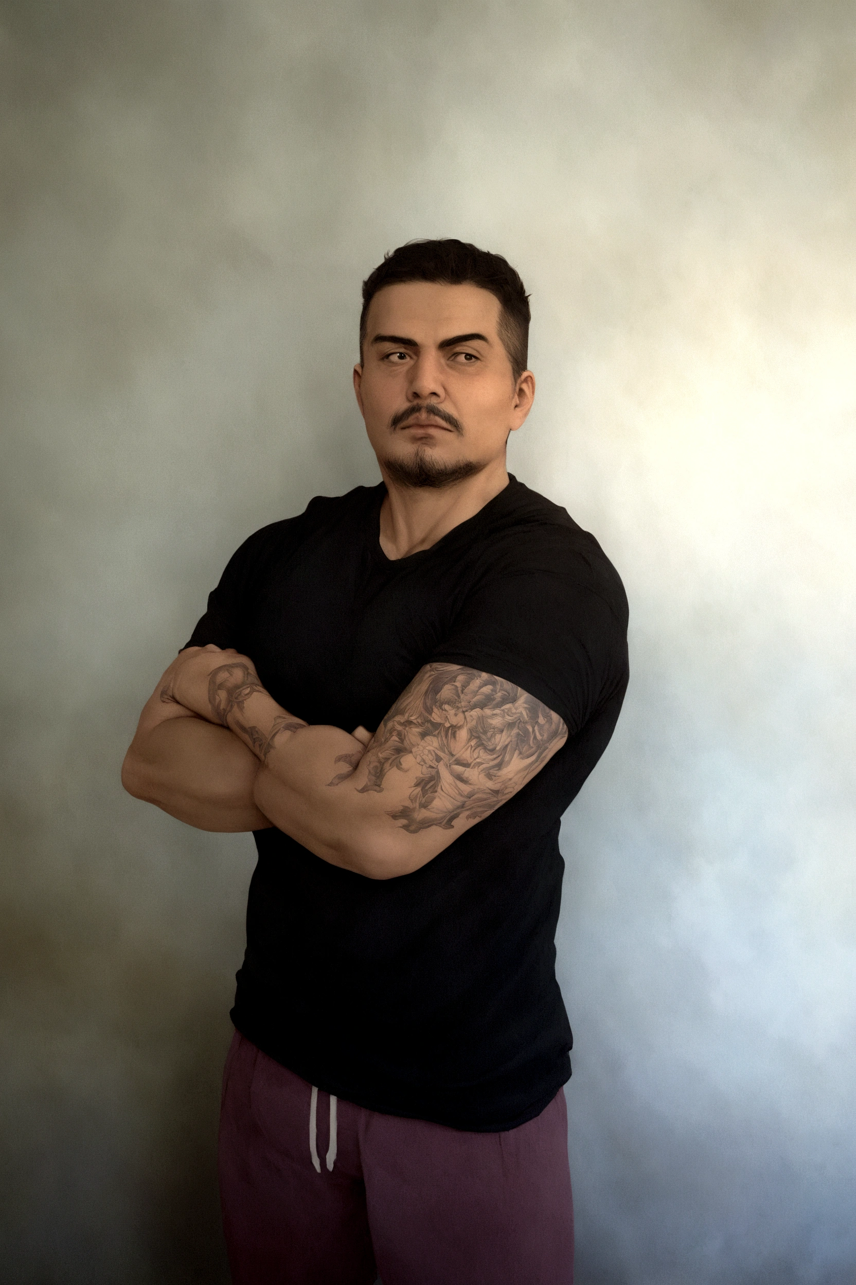 there is a man with a tattoo on his arm and a black shirt, cerca de 3 5 anos, foto de corpo inteiro, david rios ferreira, (38 anos), arms crossed on the chest, para baixo, left arm and back, cerca de 19 anos, imagem de qualidade muito baixa, 3 6 anos, 32 anos, photo taken from behind