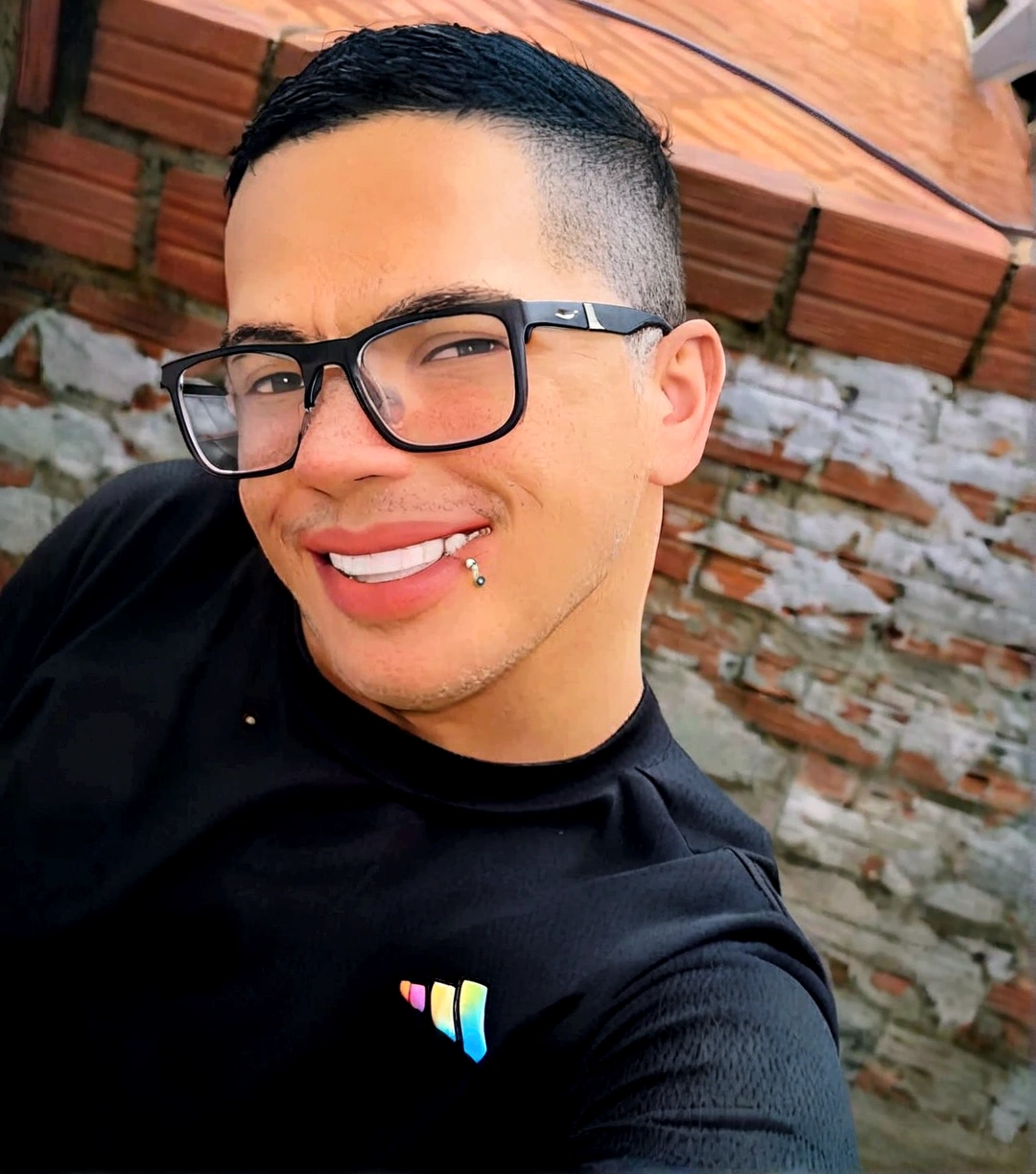 create a smiling man with glasses, wearing a black shirt, with a wall in the background as if he were a Disney and Pixar character