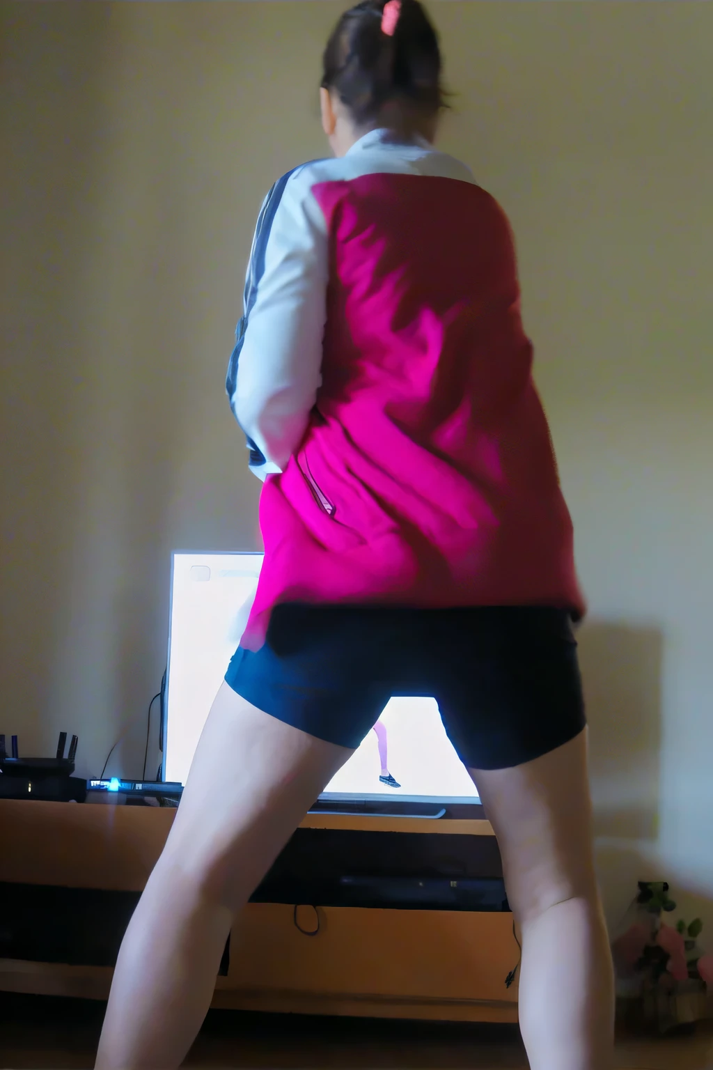 there is a woman standing in front of a tv playing a video game, long shot from back, long shot from the back, doing a sassy pose, in shorts, backshot, leg and hip shot, hip and leg shot, frantic dancing pose, back - shot, thighs!!!!!!, other women dancing behind, dancing in the background, back shot