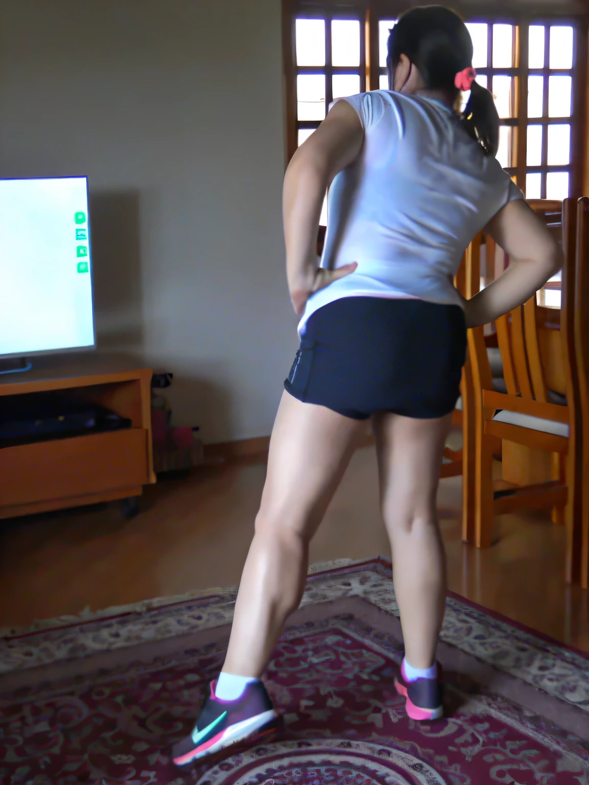 there is a woman standing in a living room playing a video game, back - shot, back shot, long shot from back, long shot from the back, back and standing, back pose, rear-shot, leg and hip shot, backshot, shot from the back, from back, centered full body rear-shot, legs and arms, back view!!