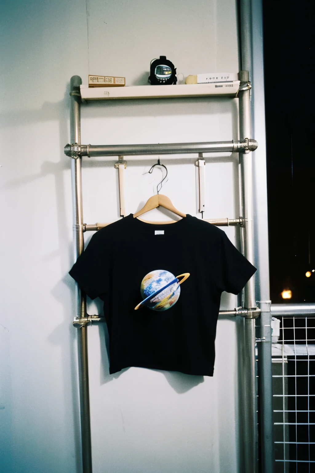 photo of to much black t-shirt, drying on the fence, located in outer space, space station grainy film analog photograph,