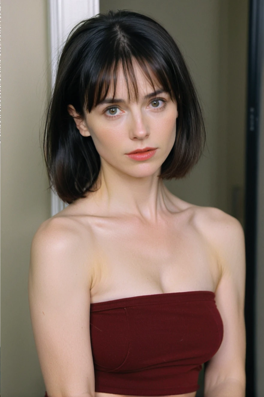 close-up of beautiful American, Jill Schoelen is a American actress, youthful face, white skin body, perfect body, Angela Shepard female character is a That Was Then... This Is Now movie, shoulder length hair, black hair, straight hair, thick flat bangs cut, bust size 34 inches, wearing a tight dark red strapless tube top, wearing a tight dark blue short legging pants, my hair was held by a boyfriend, then my boyfriend held a pair of scissors in his right hand, then cut my hair forcefully by the boyfriend using the scissors with a sigh, strand after strand of Angela's hair fell down, pieces of Angela's hair now filled the floor around where she was sitting, sexy looking pose, pose a naughty look, at a boyfriend house, UHD