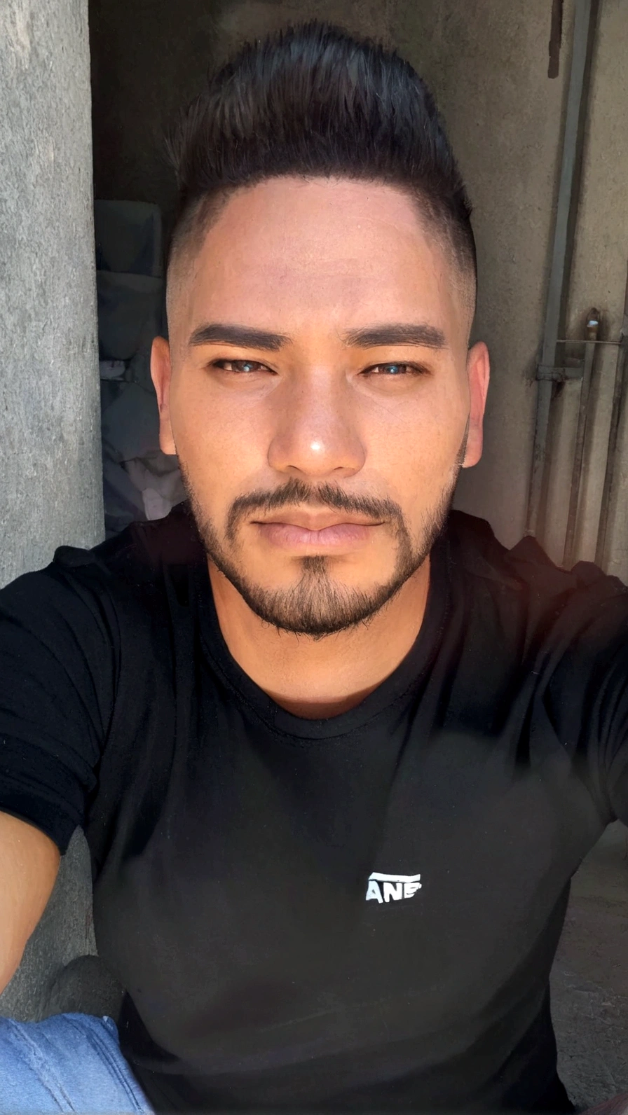 chiseled man with beard and black shirt sitting on the floor, profile picture with headshot,  cerca de 19 anos, barca curta