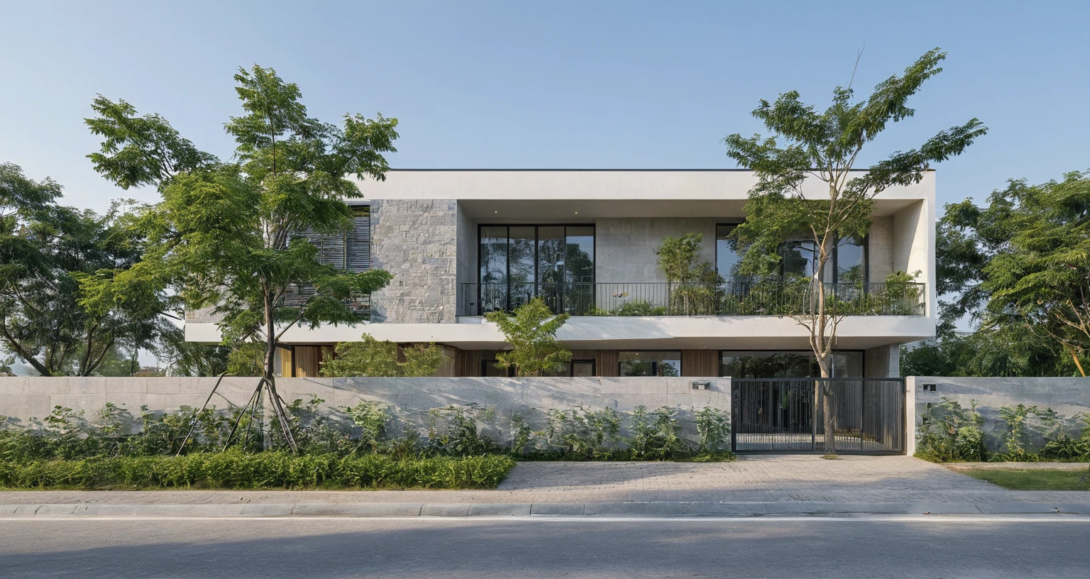 Raw photo, Masterpiece, high quality, best quality, authentic, high realistic, super detail, Realistic green tree exterior, outdoors, Tuonghoagio, house, modern stytle, on the street, wind flower wall, glass windows, GRAY STONE wall, GRAY metal gate, metal railing, house style modern on the street road, pavement, grass, trees, sky, cloud, (daylight:1.1)