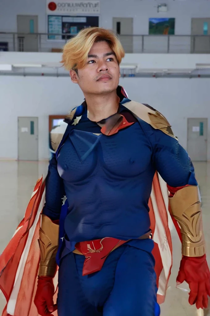 Homelander's costume heavily features American patriotic symbols, such as the stars and stripes, which underline his public persona as a hero embodying American values.
Color Scheme: The red, white, and blue color scheme is prominent, enhancing his image as the quintessential American superhero.
Armor-like Elements: His suit is designed to look almost like armor, suggesting strength and invulnerability, reflecting his superhuman abilities.
Cape and Eagle Motif: He sports a cape, often associated with traditional superheroes, and an eagle emblem on his shoulder, further reinforcing the American theme.
