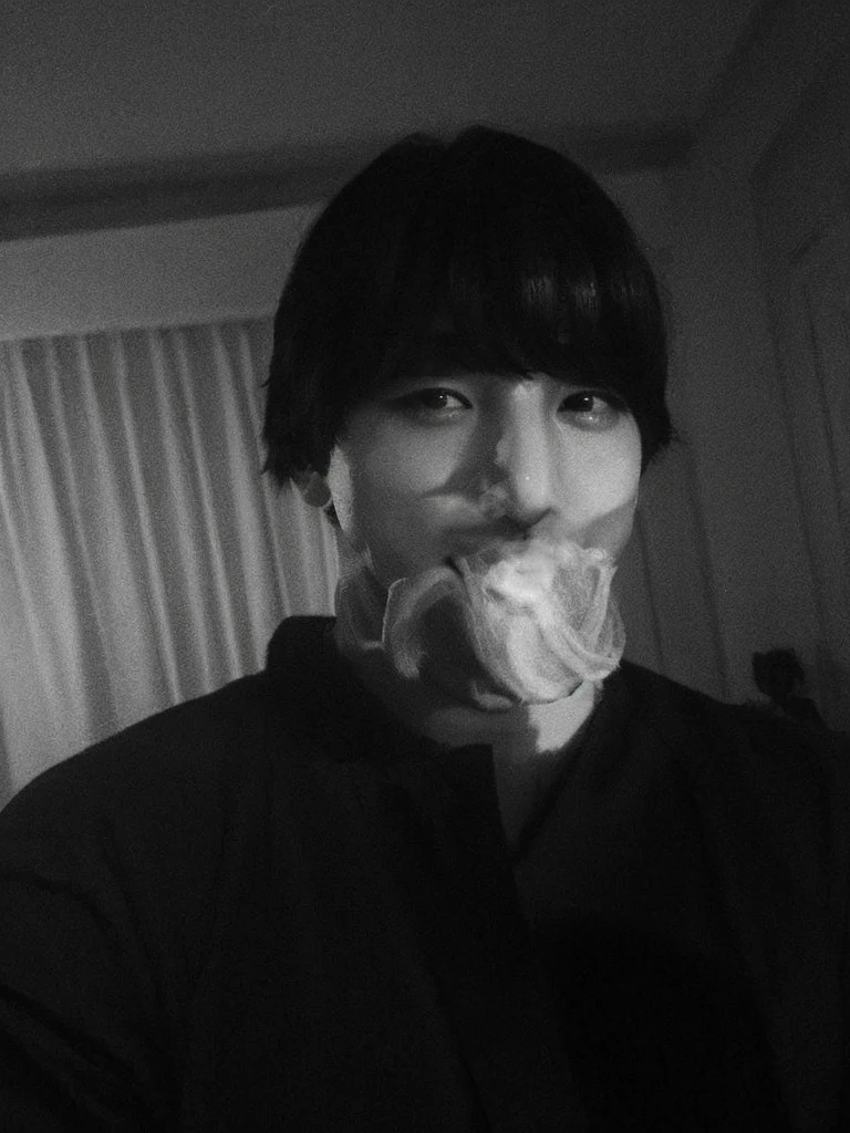 Jungkook face, mirada seria, mano en la cara tapando sus labios