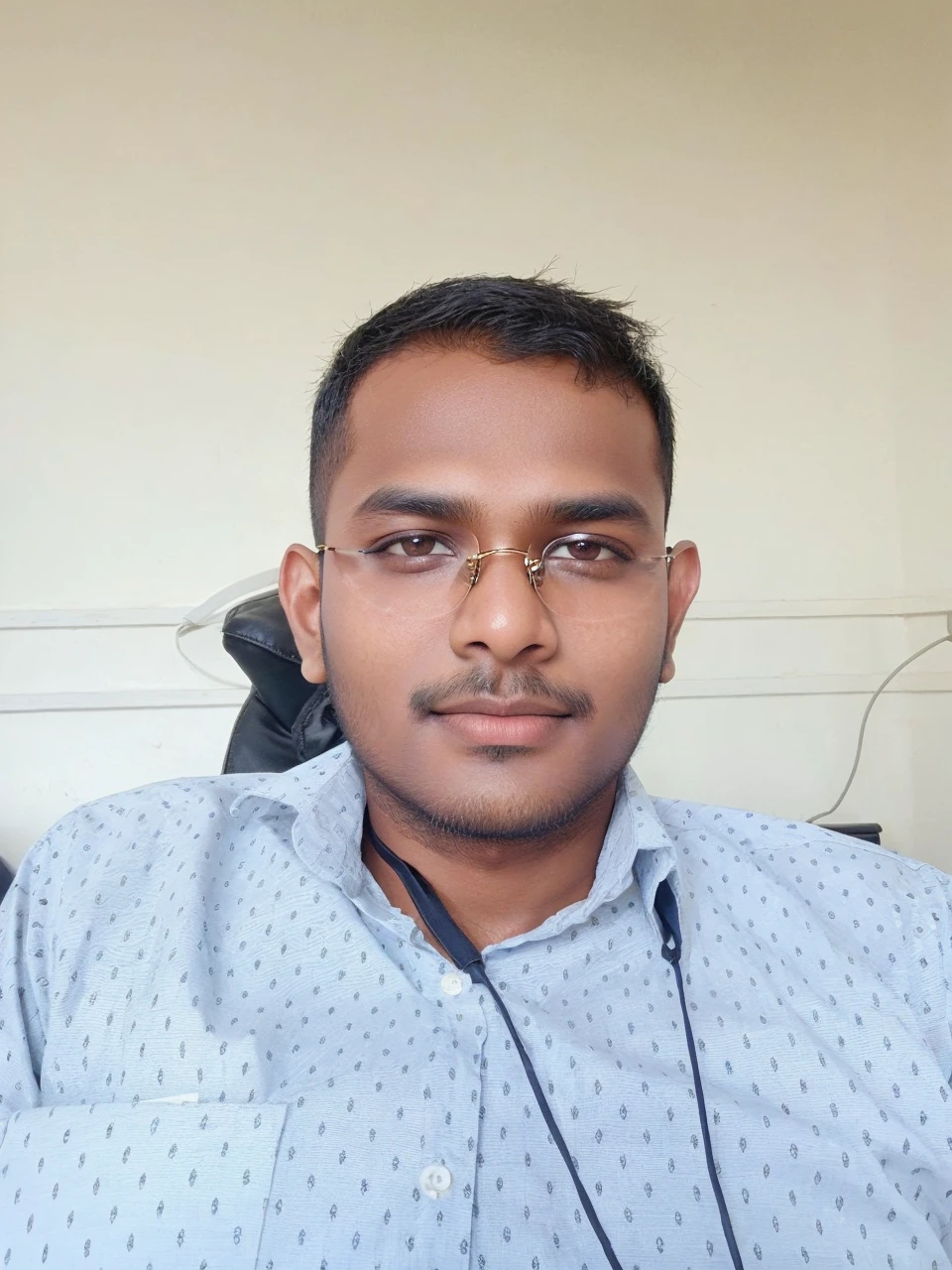 21 years old indian boy with fair skin wearing spectacles and narrow body posing for a linkdin picture in formals 