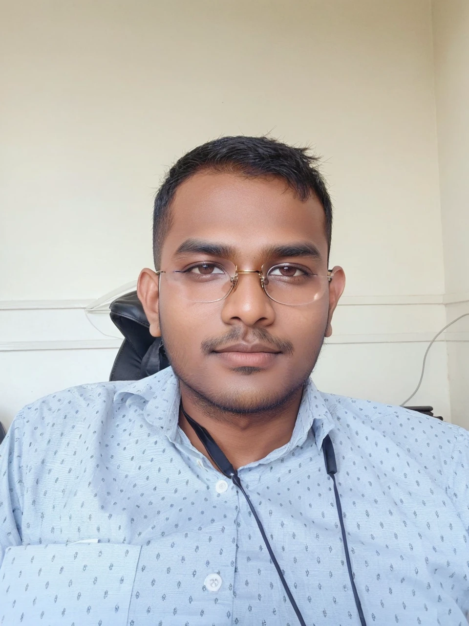 21 years old indian boy with fair skin wearing spectacles and narrow body posing for a linkdin picture in formals
