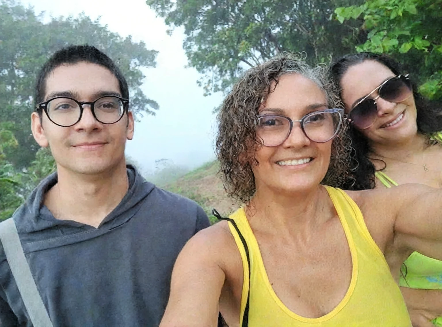 There are three people who are taking a selfie together, imagem de perfil, enevoado day outside, Nevoeiro ao fundo, imagem de avatar, imagem de perfil, powder Nándor Katona, taken at the beginning of 2020, enevoado!, com neblina, na montanha, imagem de perfilture, na frente de um fundo de floresta, com montanhas ao fundo, old camera, foto antiga, vhs.