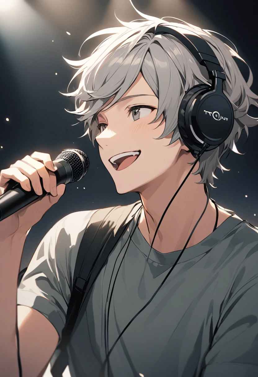 A young man with gray hair wearing headphones and speaking into a microphone. He is smiling.