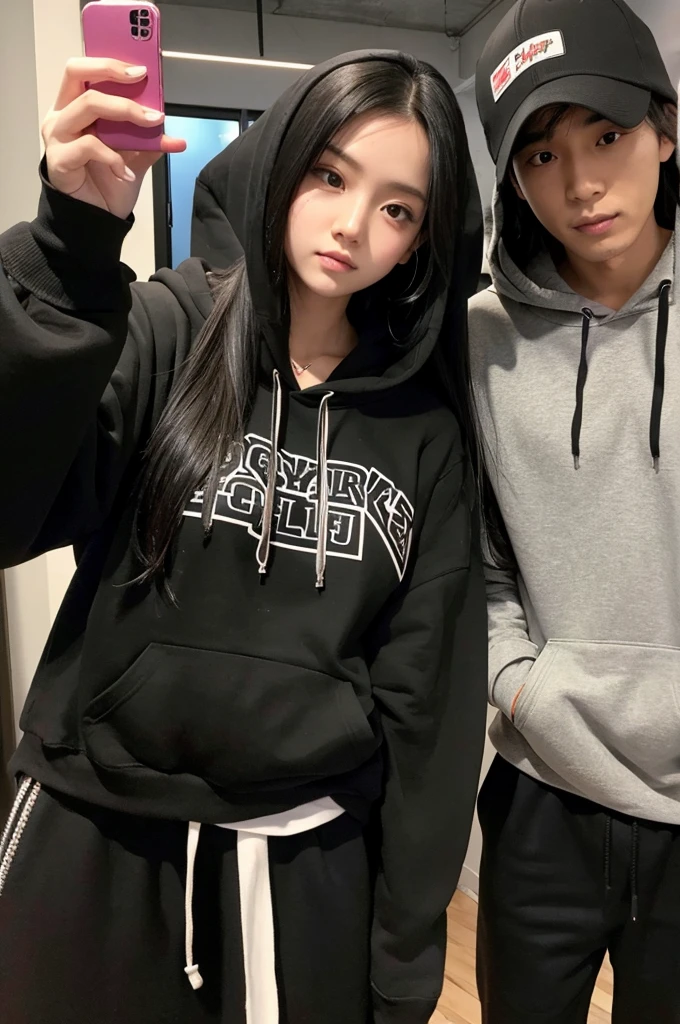 A girl with long black hair and a black hoodie takes a selfie with her tall boyfriend