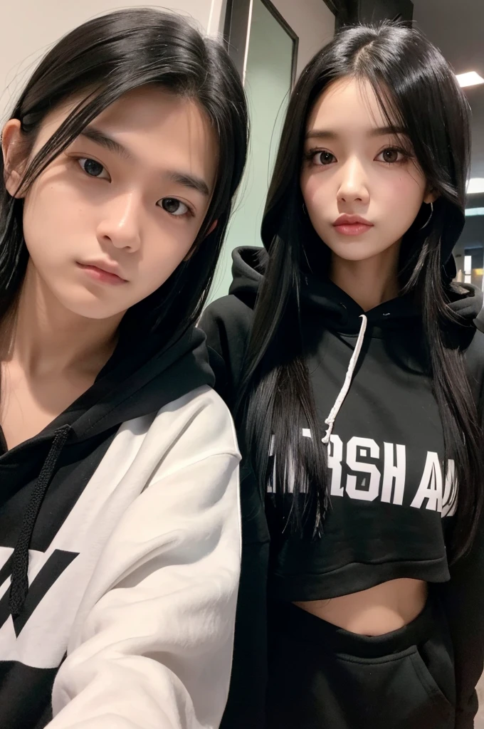 A girl with long black hair and a black hoodie takes a selfie with her tall boyfriend