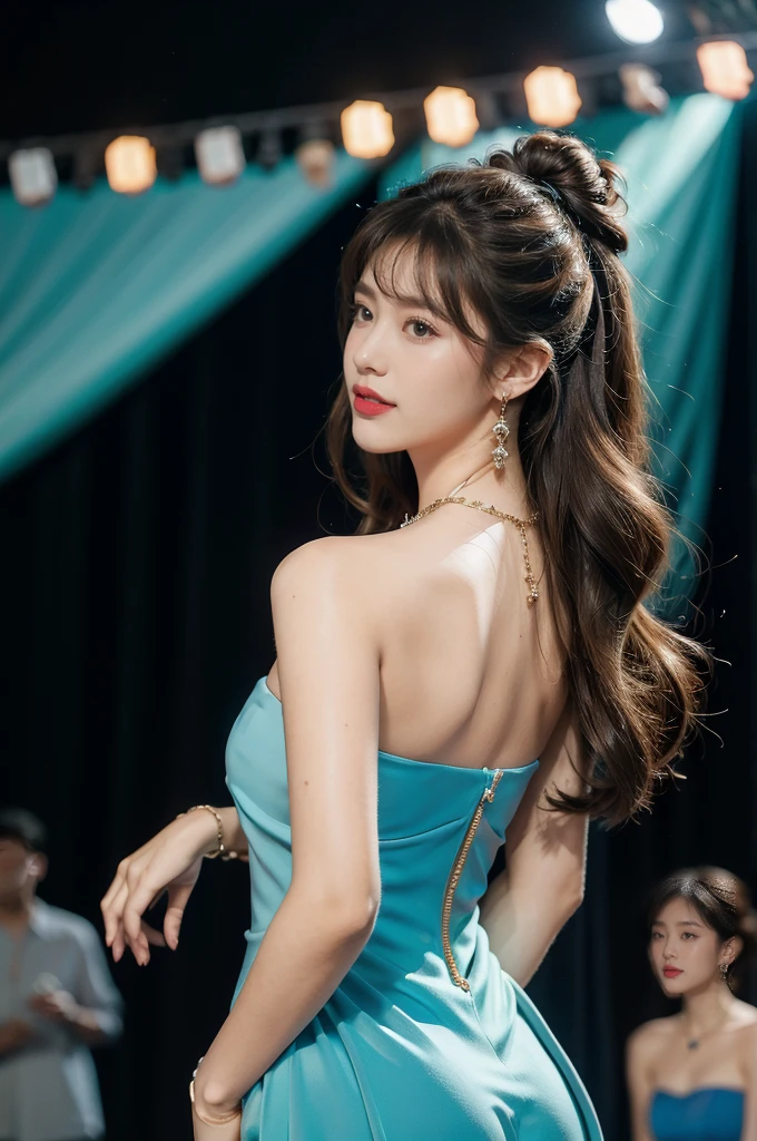 1girl,bangs,bare shoulders,necklace,strapless blue dress,detailed background,detailed eyes,brown hair,earrings,upper body,jewelry,slim,bare back,messy hair,looking at viewer,makeup,night scene,red lips,signature,laughing,solo,standing,On the T-stage,catwalk,fashion show,Surrounded by crowded crowds on both sides of the stage,neon lights,from back,towering hips,butt crack