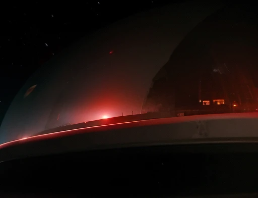 The color of the planet is gray with red, photography of the universe the ship is approaching this planet.