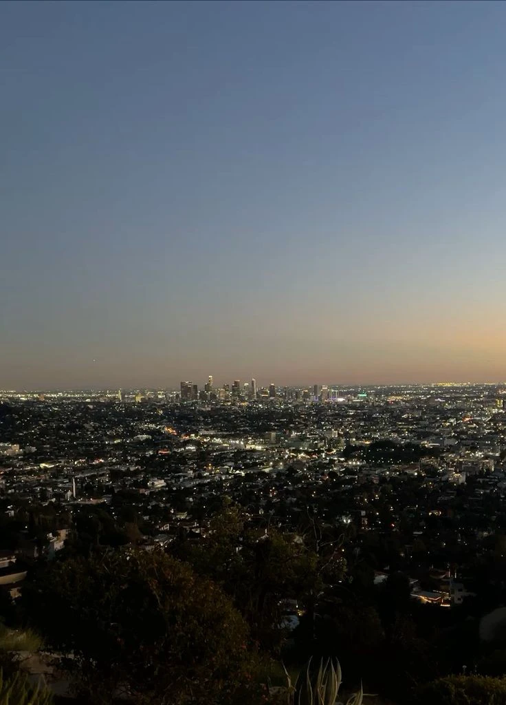 Road at the top of a hill with a city in the background seen from above