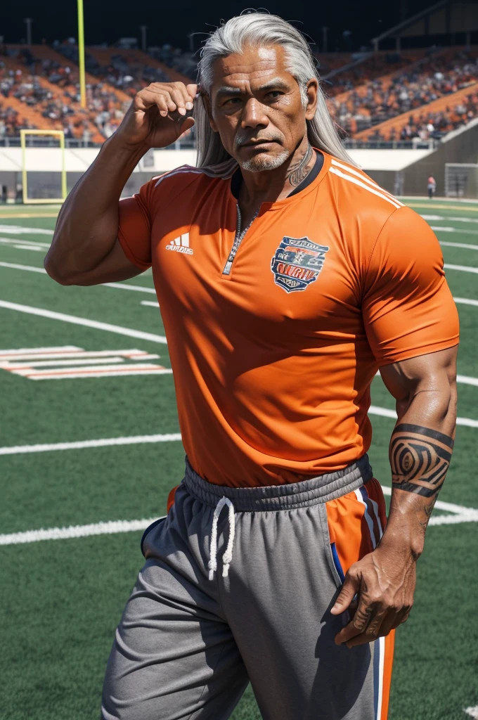 man from samoa, 60 years old, very muscular body, long gray hair, football coach, at a football field, wearing orange track suit, many tribal tattoos