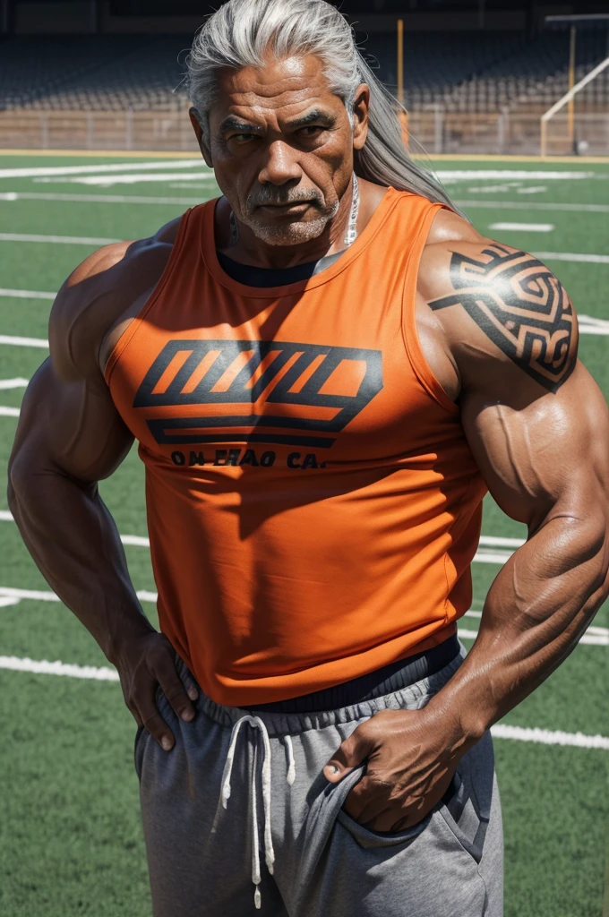 man from samoa, 60 years old, very muscular body, long gray hair, football coach, at a football field, wearing orange tank top and orange sweatpants, many tribal tattoos