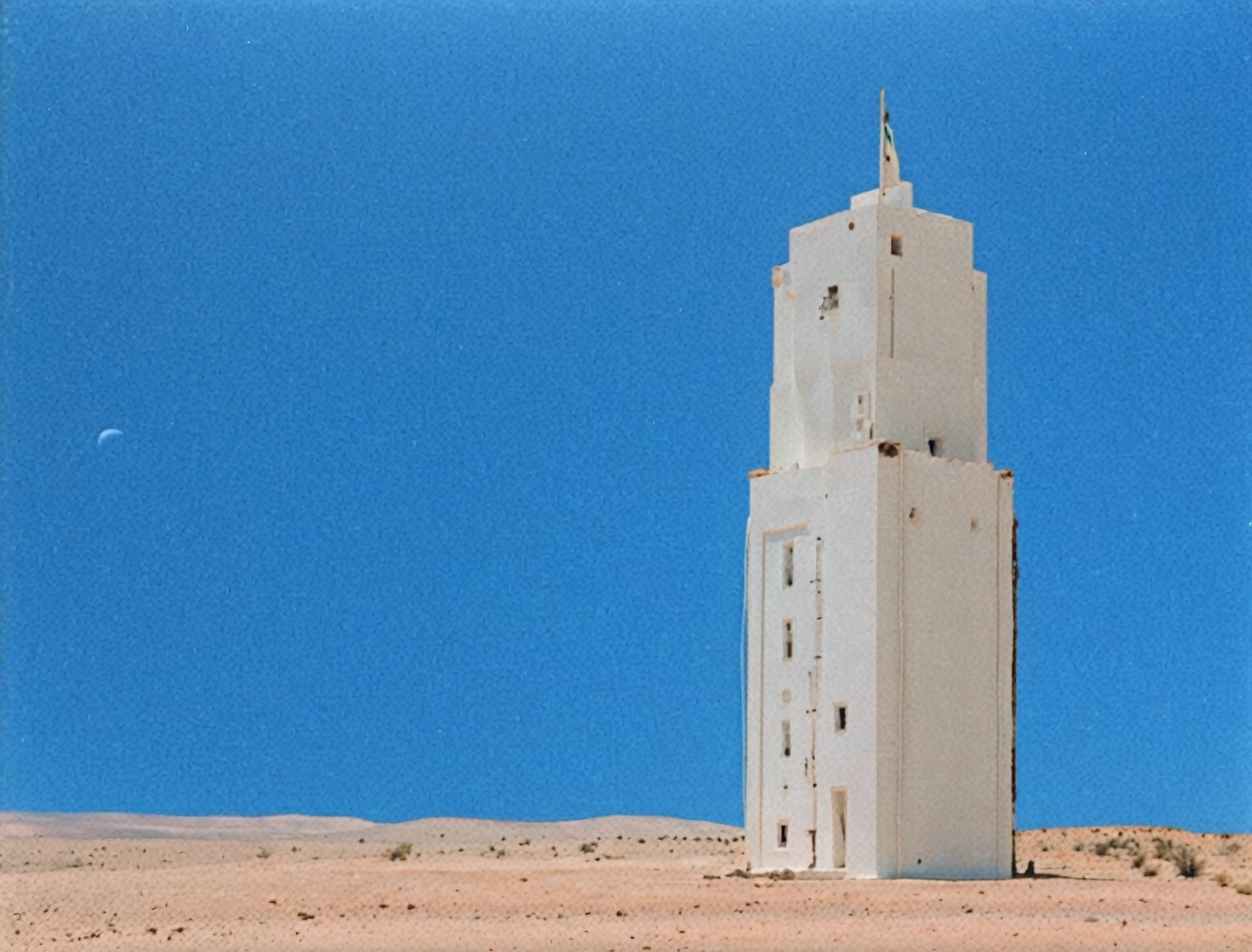 a white building in a desert with a blue sky in the background and an infinite horizon