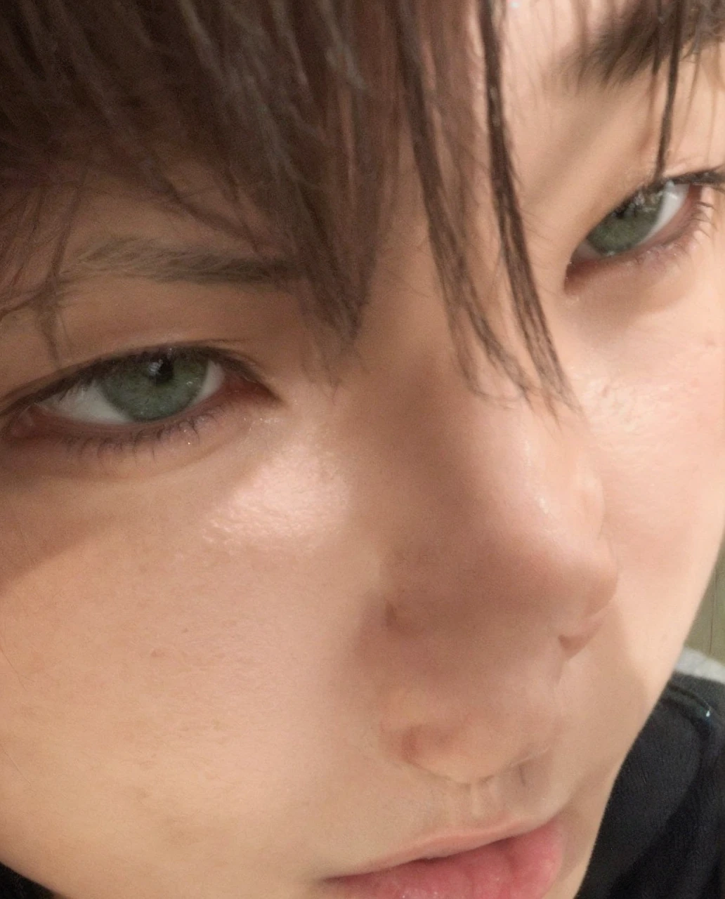 Green-eyed Asian boy with his face close to the camera, snub-nosed 