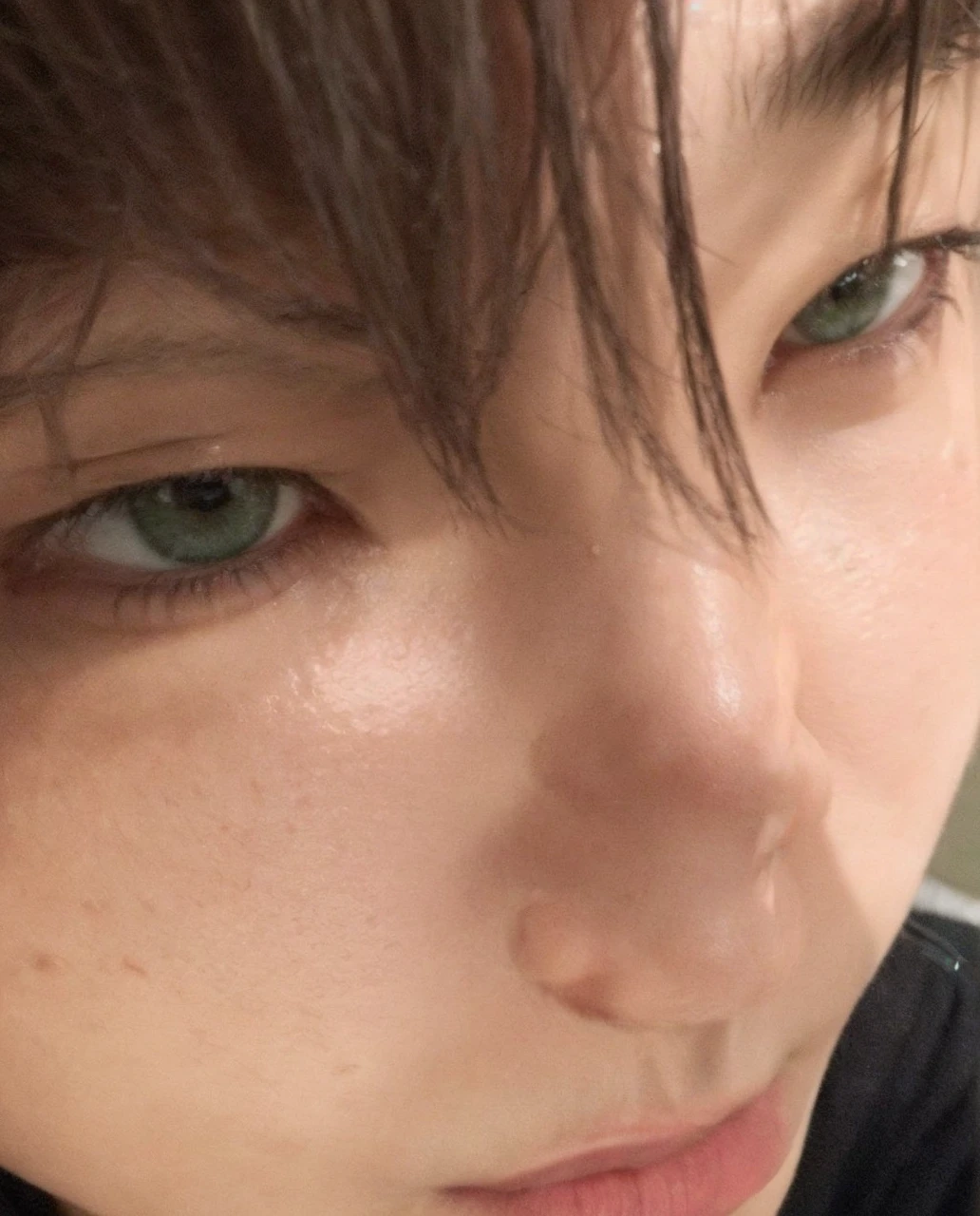 Green-eyed Asian boy with his face close to the camera, snub-nosed 