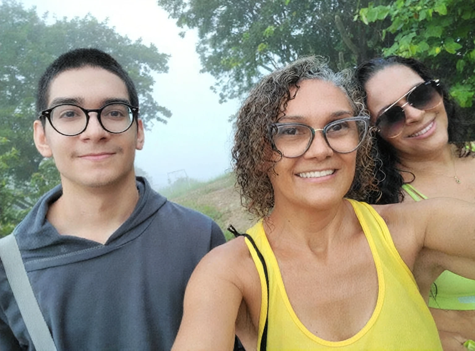 There are three people who are taking a selfie together, profile image, misty day outside, fog in the background, avatar image, profile image, powder Nándor Katona, taken at the beginning of 2020, misty!, with fog, at the mountain, profile imageture, in front of a forest background, with mountains in the background, old camera, antique photo, vhs.