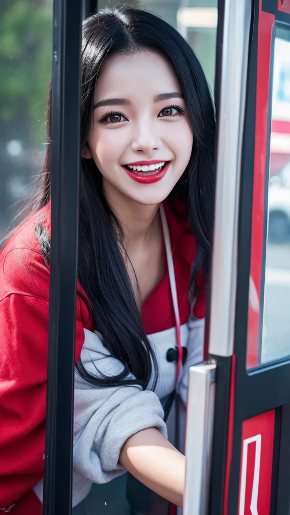 A beautiful black-haired woman transformed into Deadpool smiles with her tongue out in a phone booth