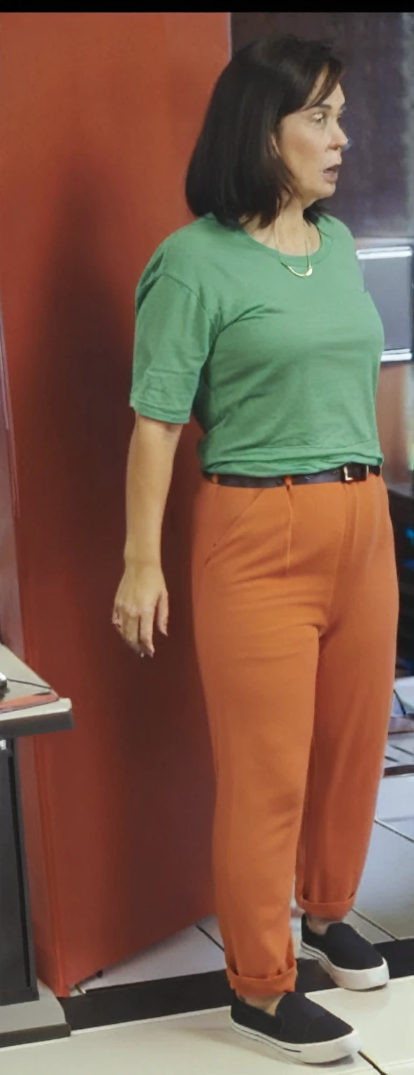 there is a woman standing in front of a computer screen, red shirt brown pants, wearing an orange t-shirt, wearing an orange t shirt, wearing pants and a t-shirt, middle shot waist up, wearing pants, wearing an orange jumpsuit, wearing orange prison jumpsuit, orange fluffy belly, vibrant but dreary orange, hand on hips, large pants