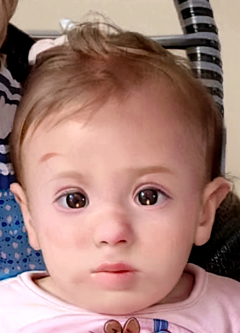 a one year old . short brown hair, beautiful and big eyes, huge brown and adorable eyes, she has a cute and expressive face, rosy cheeks, serious expression, with beautiful passionate eyes, big eyes with visible pupils