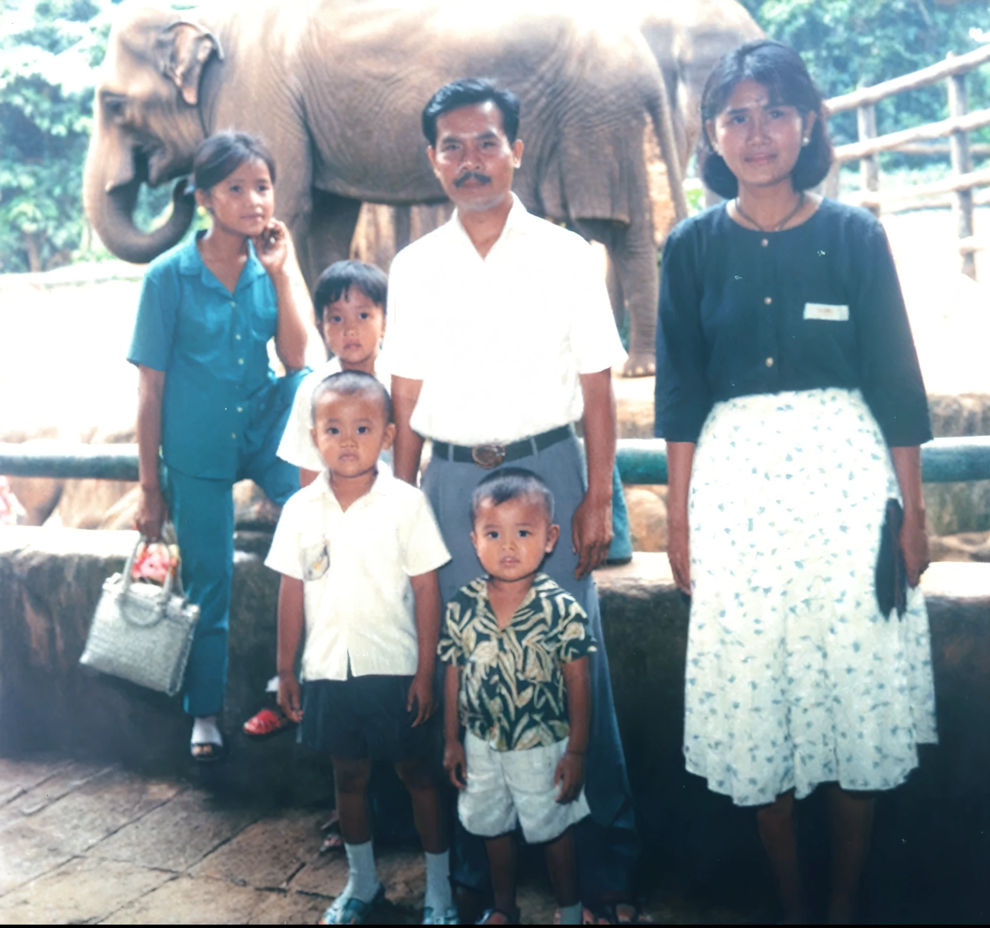 there are a group of people standing in front of an elephant, real picture taken in zoo, taken in zoo, an indonesian family portrait, old picture, 90s photo, childhood memory, 1 9 8 0 s photo, 1980s photo, 90's photo, barong family, photo 1 9 9 0 s, happy family