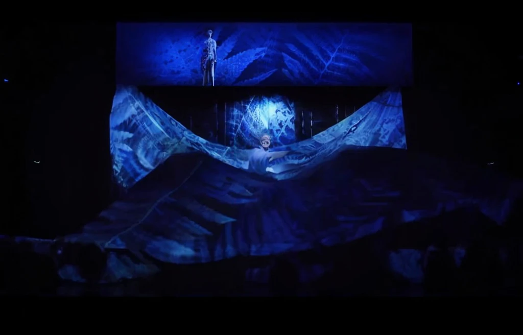 Stage scene concept、Stage lighting、Flowing curtain、arafed image of woman in skirt on stage, Projection design and installation, projection mapping, The back of the scene design element, Holographic projection, Hologram, With screens and silk, 巨大的Hologram, 空灵Hologram中心, footage of a theater stage, Alana Fletcher