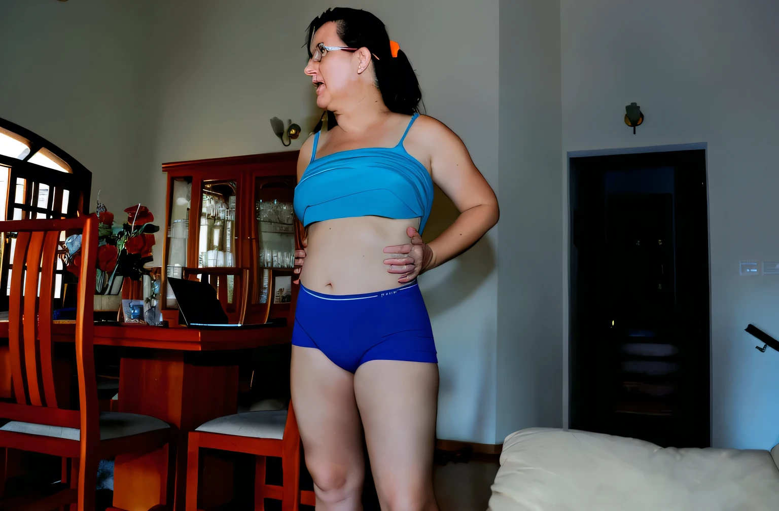 there is a woman in a blue top and blue shorts standing in a living room, blue undergarments, sport bra and dark blue shorts, middle shot waist up, bright blue shiny lingerie, belly button showing, her belly button is exposed, shot on nikon d 3 2 0 0, wearing a camisole and shorts, 3 5 year brazilian mother, short robust woman