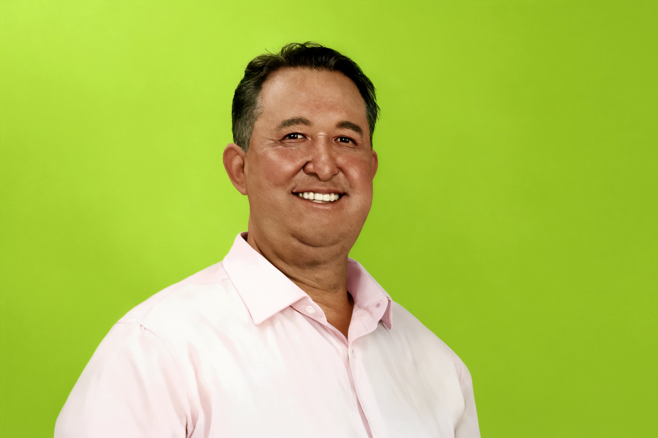 chubby man, smiling, wearing pink shirt with a green background