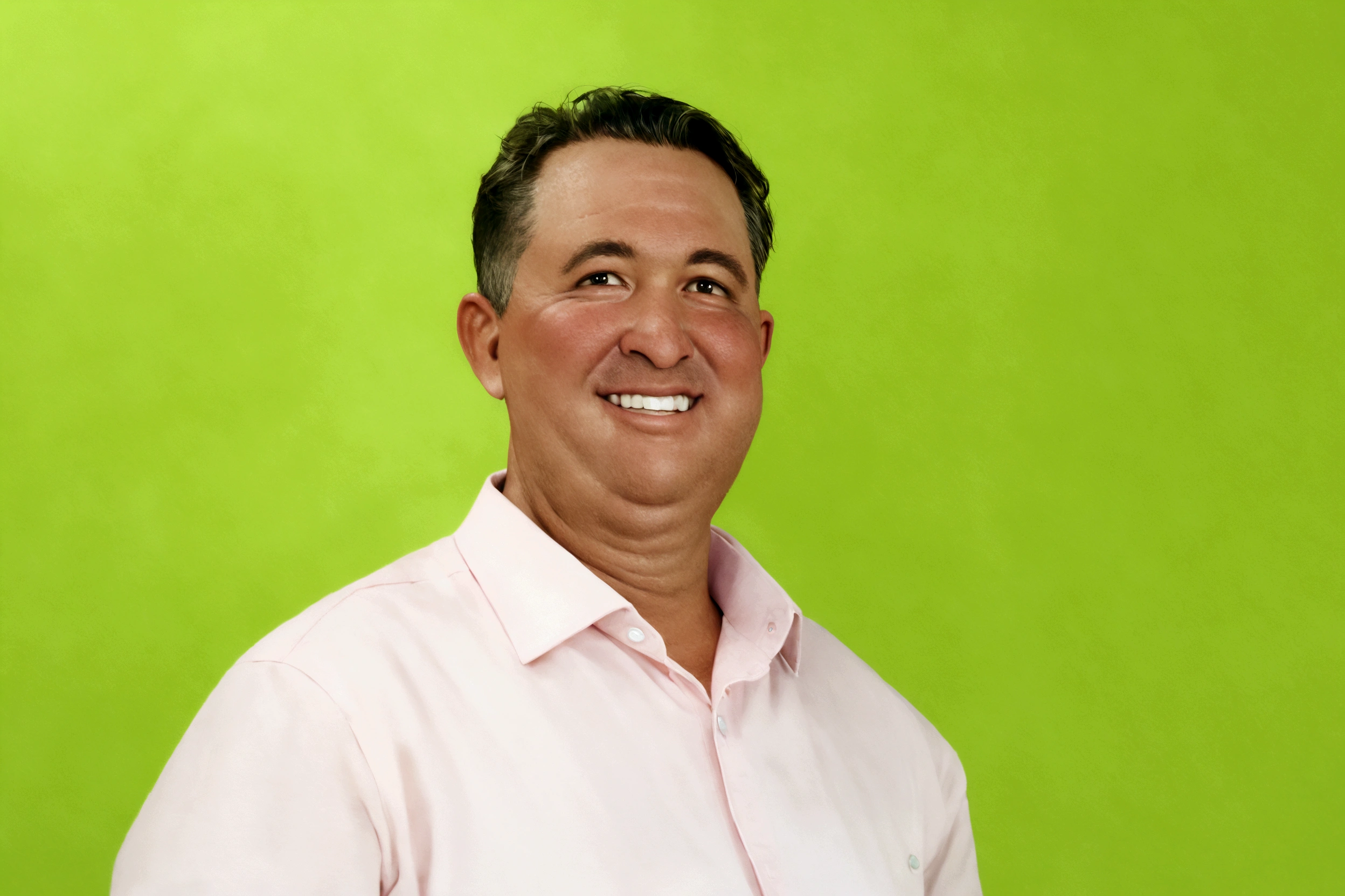 chubby man, smiling, wearing pink shirt with a green background
