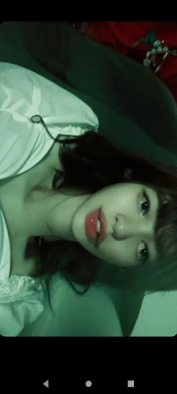 A white girl with black hair who wears bangs, her hair is long and her bangs go to her eyebrows, taking a selfie, she is wearing a star necklace, the photo is supposed to be gray and black, SHE IS SERIOUS, the image has to be as realistic as possible , She is Brazilian , shes alone, she is 17 years old, your eyes are delicate, she is wearing a little eyeliner, your nose is beautiful and your mouth is pink