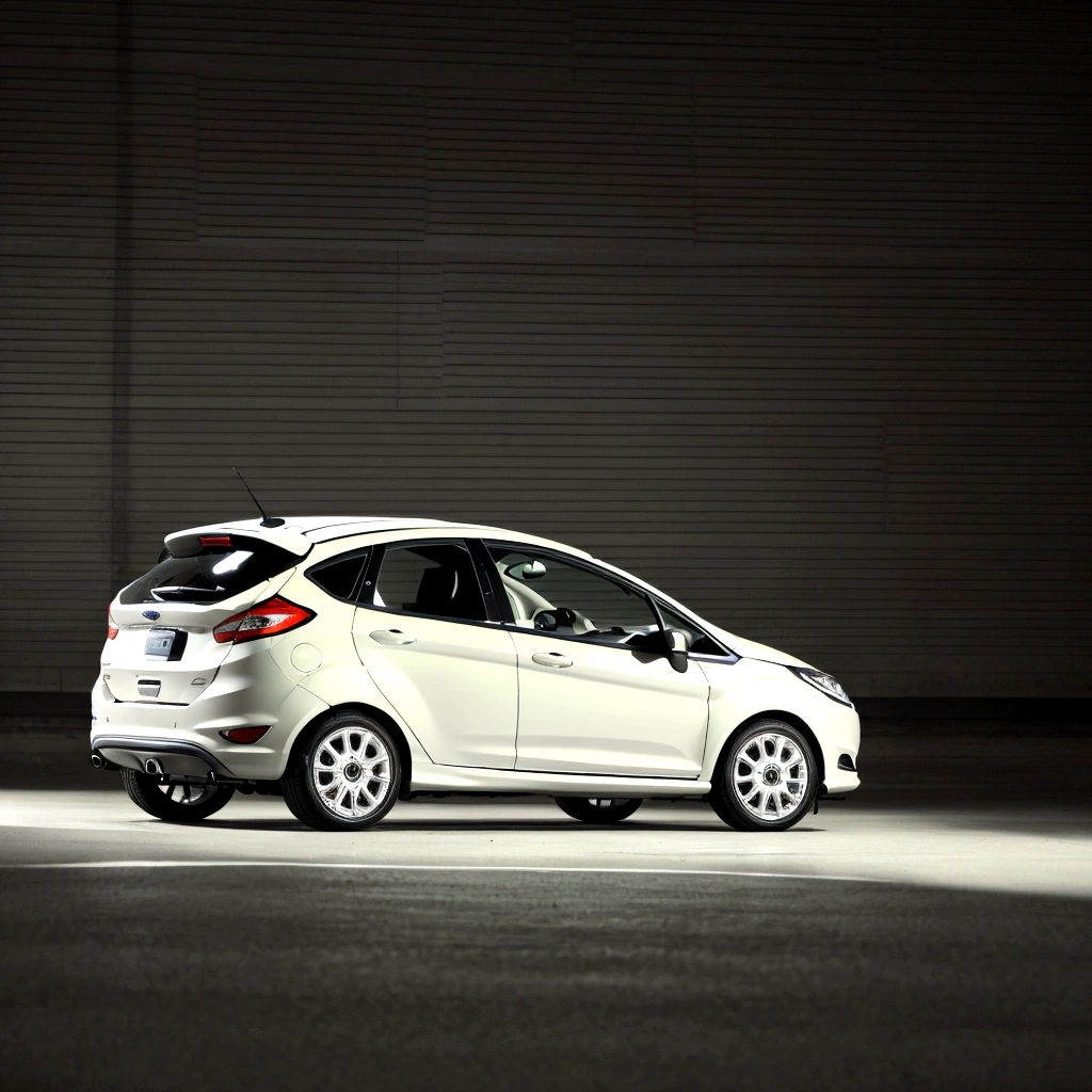 A 2011 Ford Fiesta in lead color with dark wheels, driving in the city, Raby, natta, with plat number "A 1415 WN"